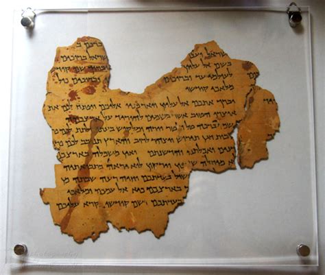 An old fragment of Hebrew scripture scroll on a white background.